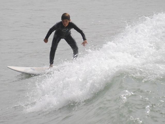 Jeune garçon prenant une vague